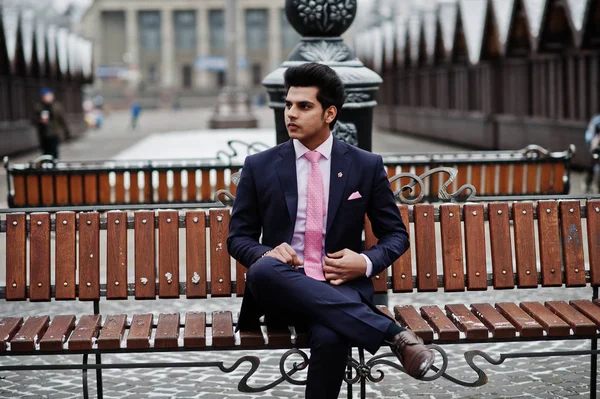 冬の日に提起し ベンチに座っているピンクのネクタイとスーツにエレガントなインドのマッチョな男モデル — ストック写真
