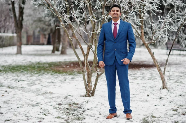 Elegant indian fashionable man model on suit posed at winter day.