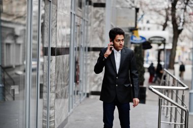 Konuşan genç Hintli takım elbise üzerinde açık, poz verdi.