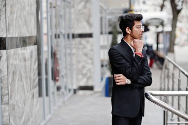 Takım elbise ve Gözlük Genç Hintli adam açık poz verdi.