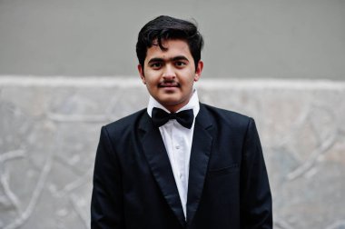 Siyah takım elbise ve kravat Genç Hintli adam açık poz verdi.