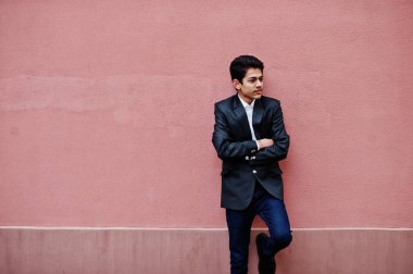 Takım elbise genç Hintli adam pembe duvara poz verdi..