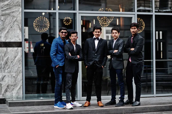 Group of 5 indian students in suits posed outdoor.