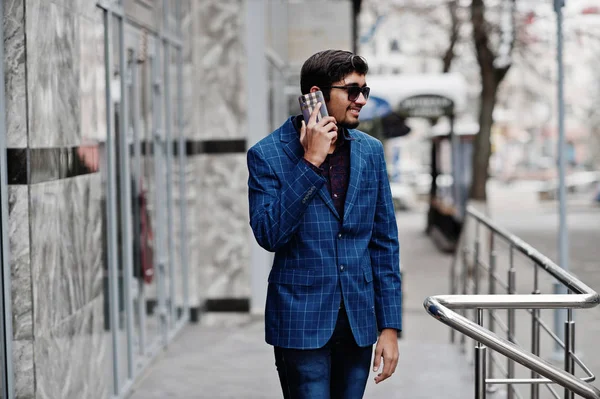スーツとサングラスの若いインド人提起屋外と電話で話す — ストック写真