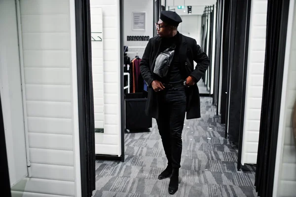 スタイリッシュなカジュアルなアフリカ系アメリカ人黒いベレー帽とコートのフィッティング ルーム服店でウエスト バッグとミラーを — ストック写真