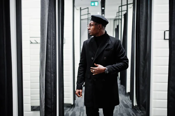 黒いベレー帽でスタイリッシュなカジュアルなアフリカ系アメリカ人およびオーバー コート試着室で服店 — ストック写真