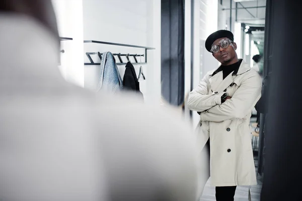 スタイリッシュなカジュアルなアフリカ系アメリカ人黒いベレー帽とフィッティング ルーム服店で白いトレンチ レインコートで鏡を見て — ストック写真