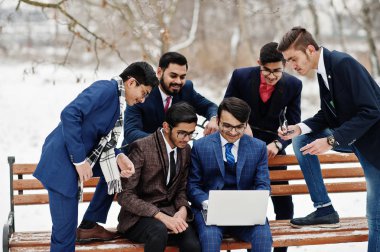 Takım elbiseli altı Hintli işadamı grubu Avrupa laptop arıyorum, kış günü açık poz.