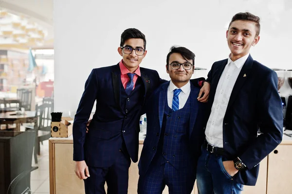 Group of three indian businessman in suits standing on cafe.