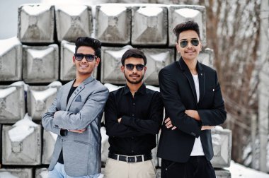 Taş bloklar karşı yöneltilen güneş gözlüğü üç sıradan genç Hint grup mans.