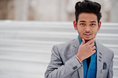 Gümüş ceketli Casual Hint delikanlı çelik arka planı poz verdi..