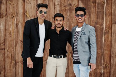 Hint mans üç sıradan genç grup karşı ahşap arka plan poz verdi..
