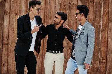 Hint mans üç sıradan genç grup karşı ahşap arka plan poz verdi..