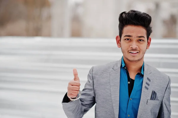 休闲年轻的印度男子在银色夹克摆在钢背景 显示拇指 — 图库照片