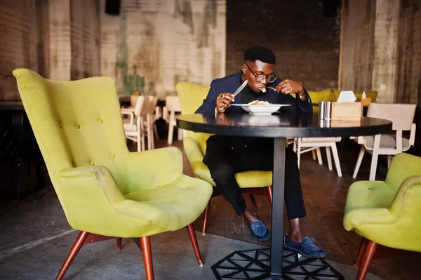 スーツと眼鏡のカフェで座っていると サラダを食べることでファッショナブルなアフリカ系アメリカ人 — ストック写真