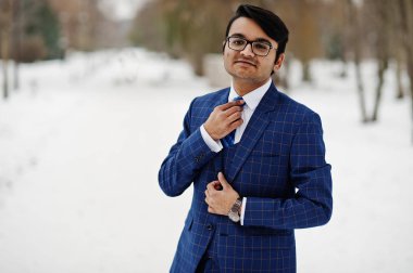 Şık Hint iş adamı takım elbise ve gözlük kış günü açık poz verdi..