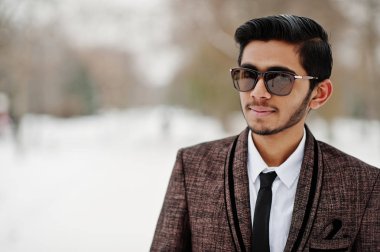 Takım elbise ve güneş gözlüğü, kış günü açık poz şık Hint öğrenci adam portresi kapatın.