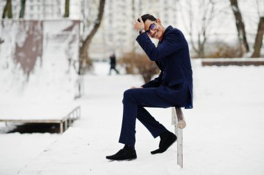 Şık Hint öğrenci erkek takım elbise ve gözlük kış günü açık poz verdi..