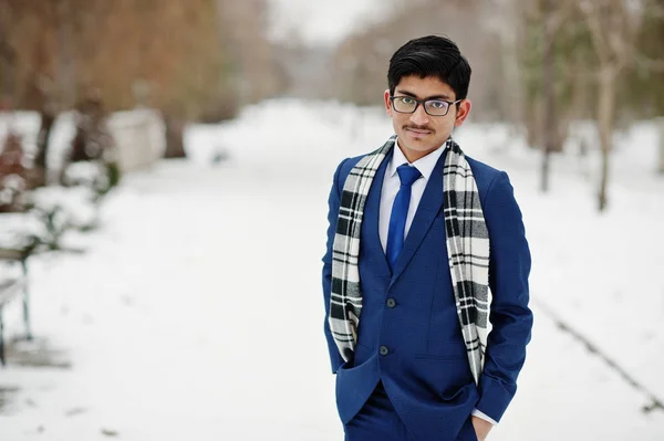 Stylish indian student man in suit, glasses and scarf posed at winter day outdoor.
