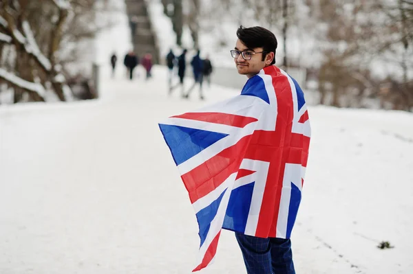 Stylish indian man in suit with Great Britain flag posed at winter day outdoor.