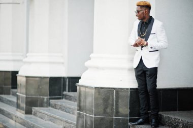 Şık yakışıklı Afrikalı-Amerikalı adam beyaz takım elbise ve güneş gözlüğü.