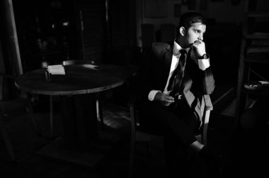 Siyah elbiseli adam zarif Güney Asya Hint iş kapalı güneş gölgeler kafede poz verdi..