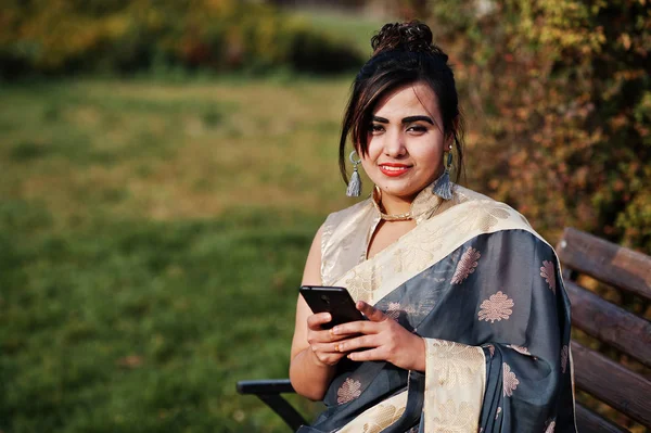 Elegant Brunett Sydasiatiska Indisk Flicka Saree Sitter Bänken Med Mobiltelefon — Stockfoto