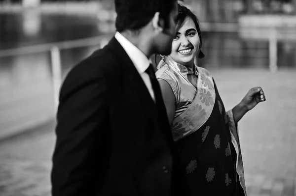 サリーの女は 一緒に歩くと手を繋いでいるスーツの男のエレガントでファッショナブルなインドの友人カップル — ストック写真