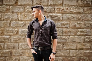 Kahverengi gömlekli Hintli adam tuğla arka plan açık poz verdi.