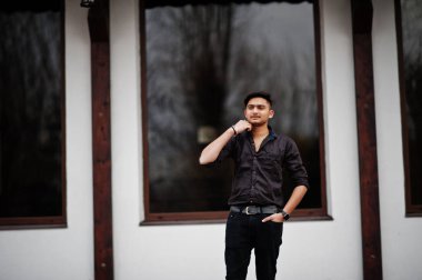 Kahverengi gömlekli Hintli adam açık poz verdi.