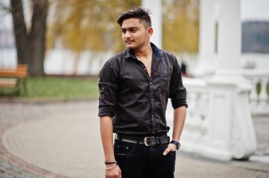 Kahverengi gömlekli Hintli adam açık poz verdi.