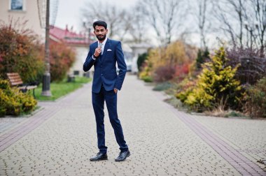 Şık sakal Hintli adam bindi alnına, ile mavi giymek takım elbise poz açık.