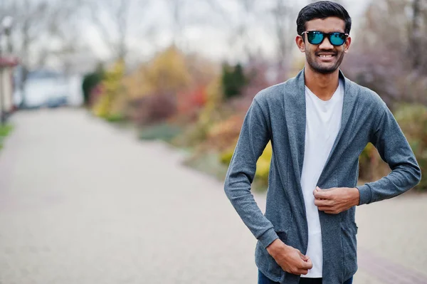 Stylish indian man at sunglasses wear casual posed outdoor.