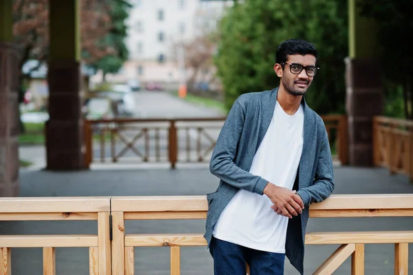 Stylish indian man at glasses wear casual posed outdoor.