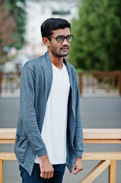 Stylish indian man at glasses wear casual posed outdoor.