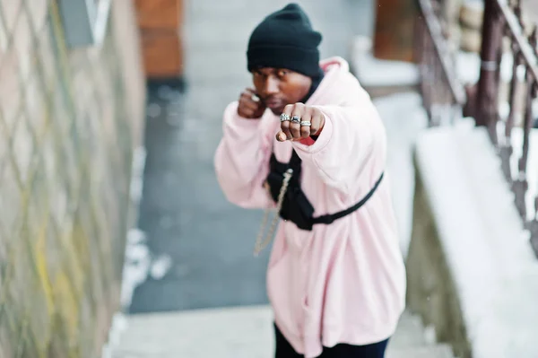 ピンクのパーカー冬の日に提起し 手をボクシングでスタイリッシュな都会的なスタイルのアフリカ系アメリカ人 — ストック写真