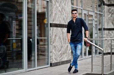 Şık Hint modeli adam rahat kıyafetler ve güneş gözlüğü Street Hindistan Açık poz verdi.