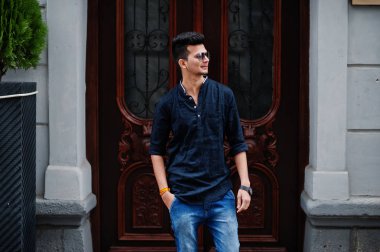 Şık Hint modeli adam rahat kıyafetler ve güneş gözlüğü Street Hindistan Açık poz verdi.