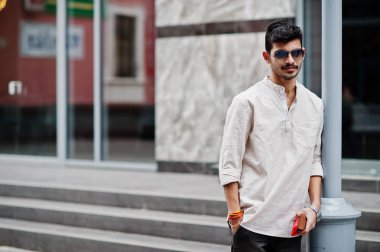 Şık Hint modeli adam rahat kıyafetler ve güneş gözlüğü Street Hindistan Açık poz verdi.
