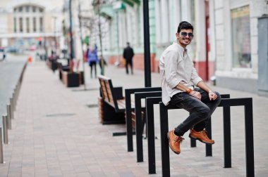 Şık Hint modeli adam rahat kıyafetler ve güneş gözlüğü Street Hindistan Açık poz verdi.