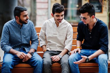 Grup üç Hint elbise dostluk birliktelik mans. Hindistan'ın Street bankta oturan çocuklar.