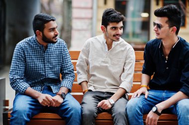 Grup üç Hint elbise dostluk birliktelik mans. Hindistan'ın Street bankta oturan çocuklar.
