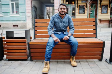 Hindistan'ın Street bankta oturmuş rahat kıyafetler şık Hint sakal modeli adam açık, poz verdi.