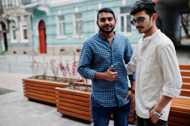 İki Hint mans, rahat giysiler üzerinde Hindistan Caddesi'nde açık poz verdi. Onlar gösterir başparmak yukarı.