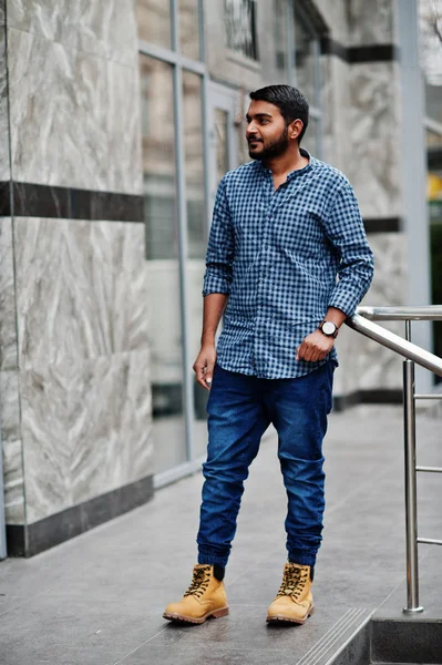 un joven indio casual con camisa azul y chaleco negro posó en el día de  invierno. 10573387 Foto de stock en Vecteezy