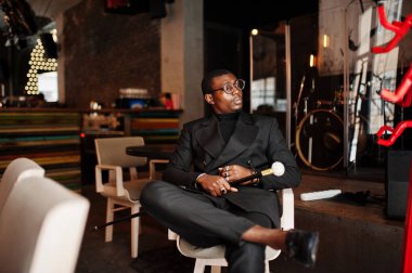 Zarif siyah ceket ve gözlük, holding retro baston baston şişesi veya altın elmas topu saplı tippling kamışı olarak şık Afro-Amerikan beyefendi. Zengin moda afro adam.