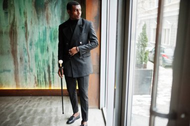 Zarif siyah ceket, holding retro baston baston şişesi veya altın elmas topu saplı tippling kamışı olarak şık Afro-Amerikan beyefendi. Zengin moda afro adam.