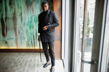 Zarif siyah ceket, holding retro baston baston şişesi veya altın elmas topu saplı tippling kamışı olarak şık Afro-Amerikan beyefendi. Zengin moda afro adam.