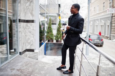 Zarif siyah ceket, holding retro baston baston şişesi veya altın elmas topu saplı tippling kamışı olarak şık Afro-Amerikan beyefendi. Zengin moda afro adam.