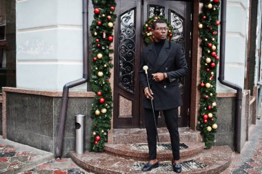 Zarif siyah ceket, holding retro baston baston şişesi veya altın elmas topu saplı tippling kamışı olarak şık Afro-Amerikan beyefendi. Zengin moda afro adama karşı Noel süsleri.